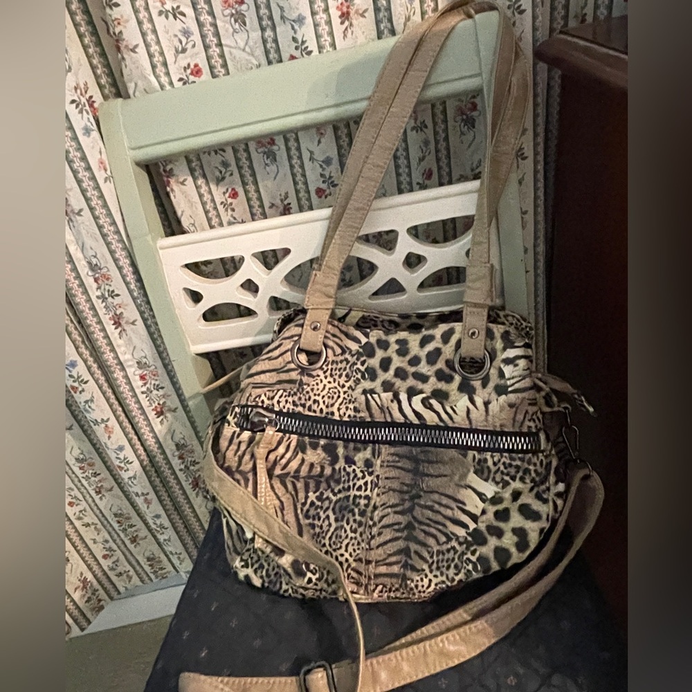 Animal print purse with shoulder, cross body straps, and multiple pockets.
